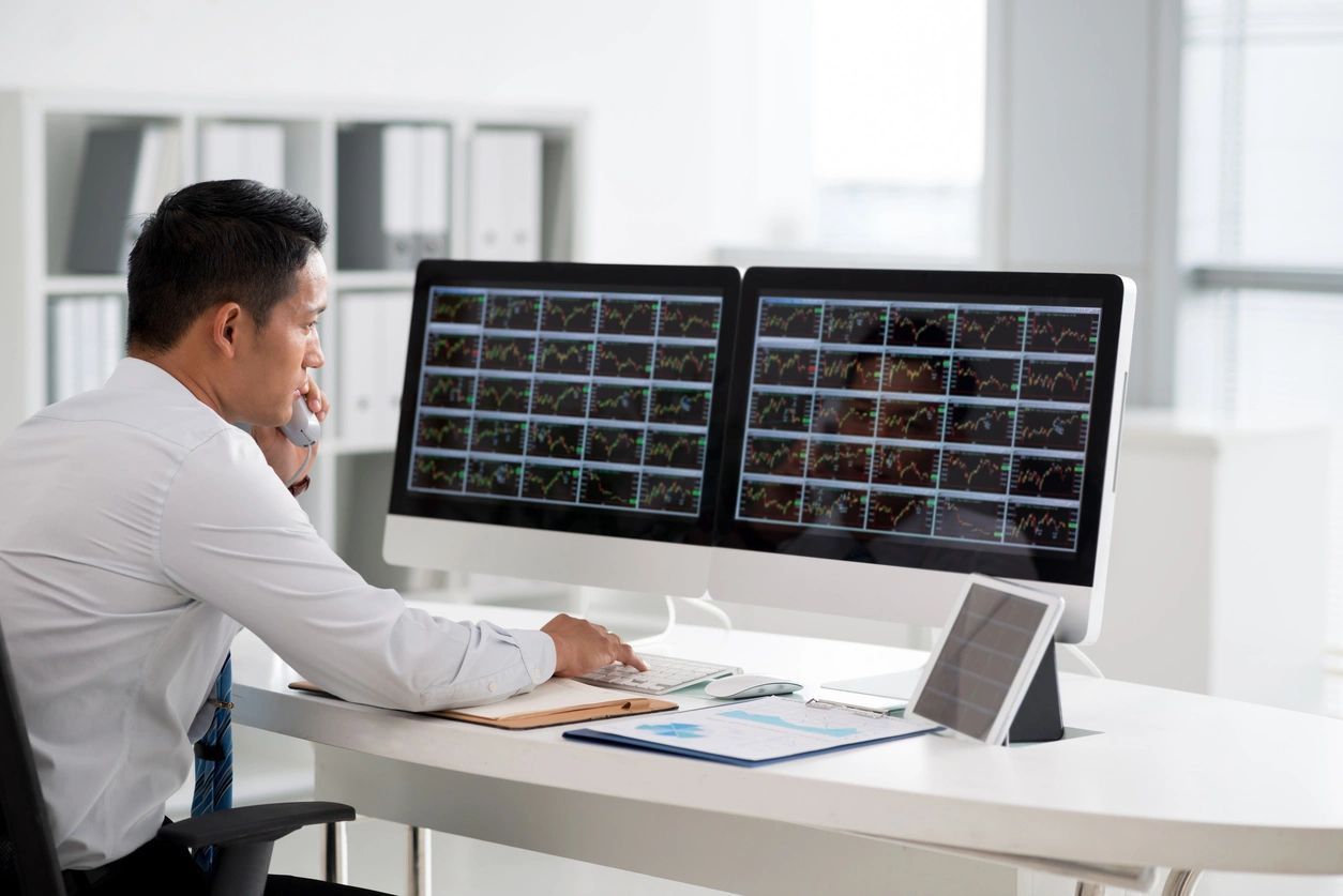Staff seated in front of two computer screens with digital dashboards